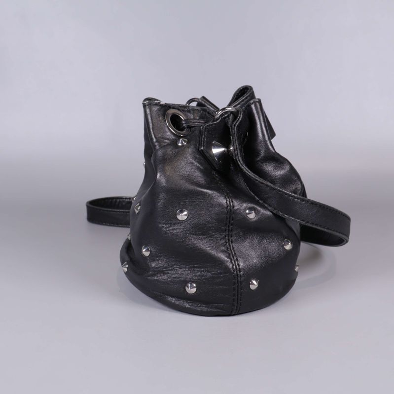 Närbild på sidan av svart väska med nitar och synlig söm