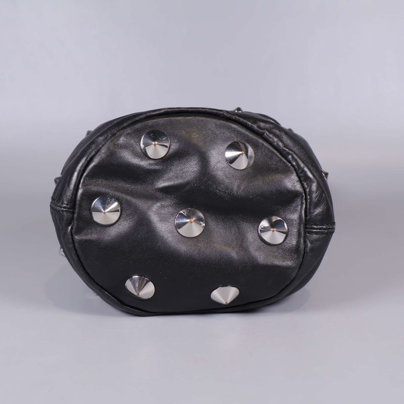 Botten på svart bucket bag med silverfärgade nitar