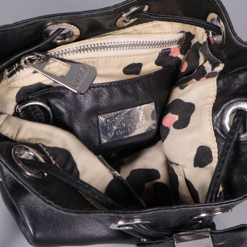 Insidan av svart bucket bag med leopardmönstrat innerfoder och dragkedja