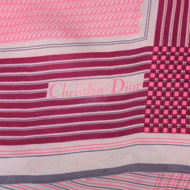 Närbild av Christian Dior-logga på rutig och randig scarf