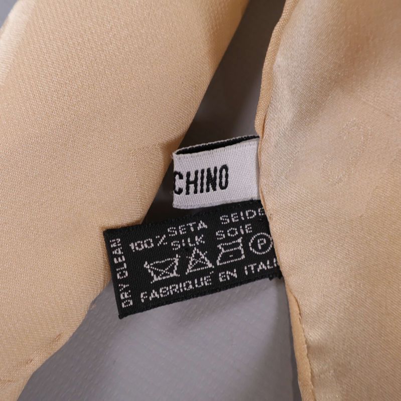 Materialetikett med texten 100% Seta Silk Soie