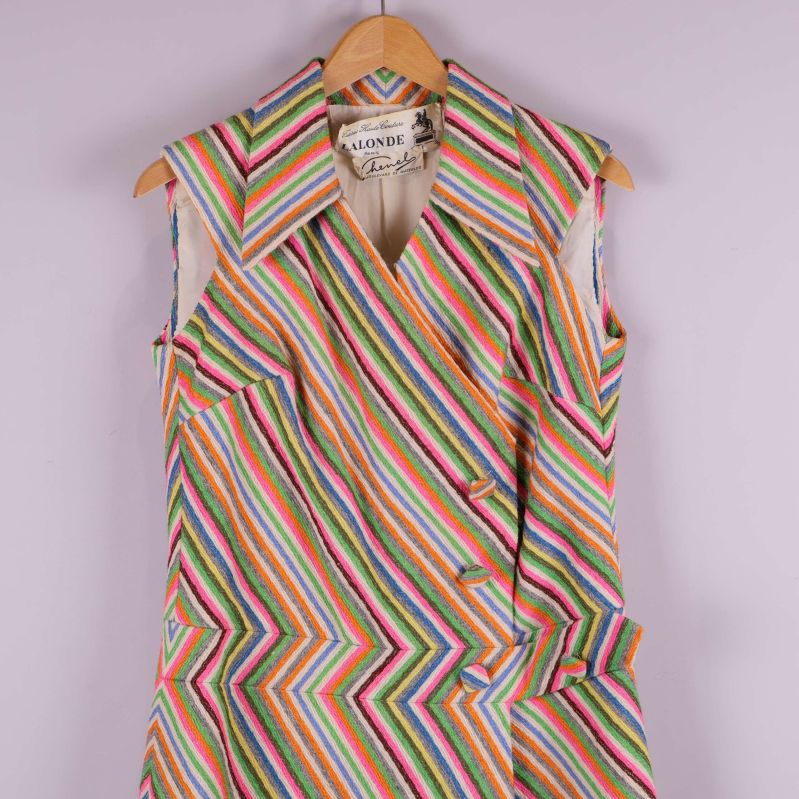 Närbild på överdelen av klänningen med spetsig krage och knappar