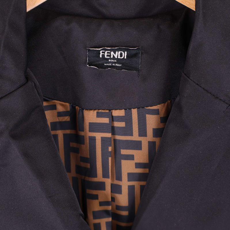 Närbild på Fendi-logotyp och mönstrat brunt innerfoder i kappan