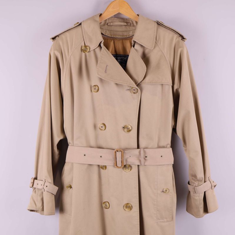 Detaljbild av trenchcoatens dubbelknäppning och bälte