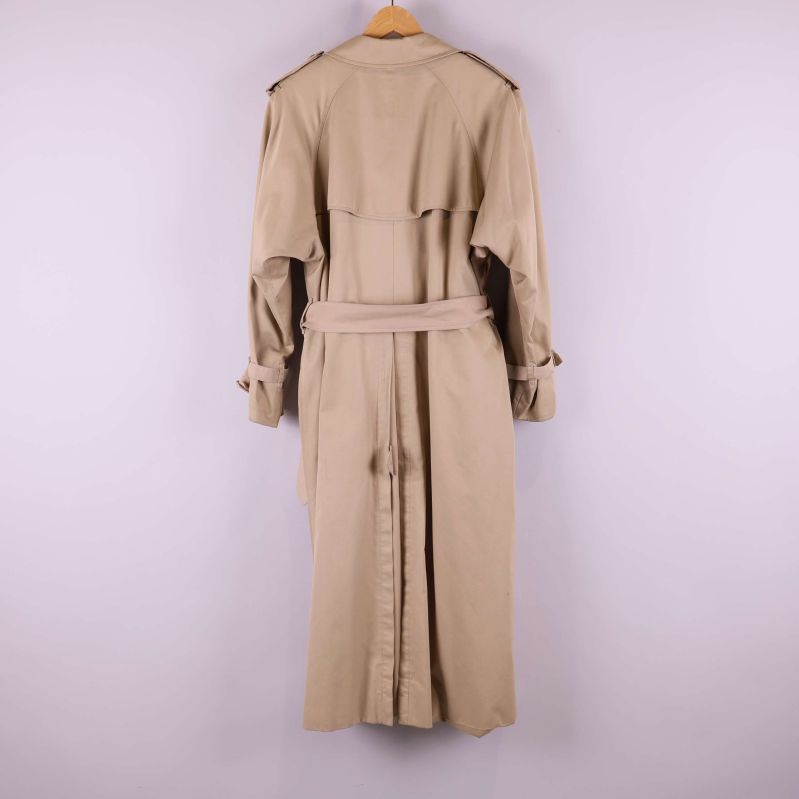 Baksida av beige trenchcoat med bälte och axelklaffar