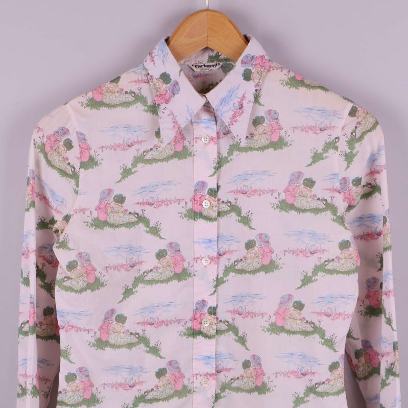 Närbild av skjortans framdel med pastellmönster och blommotiv