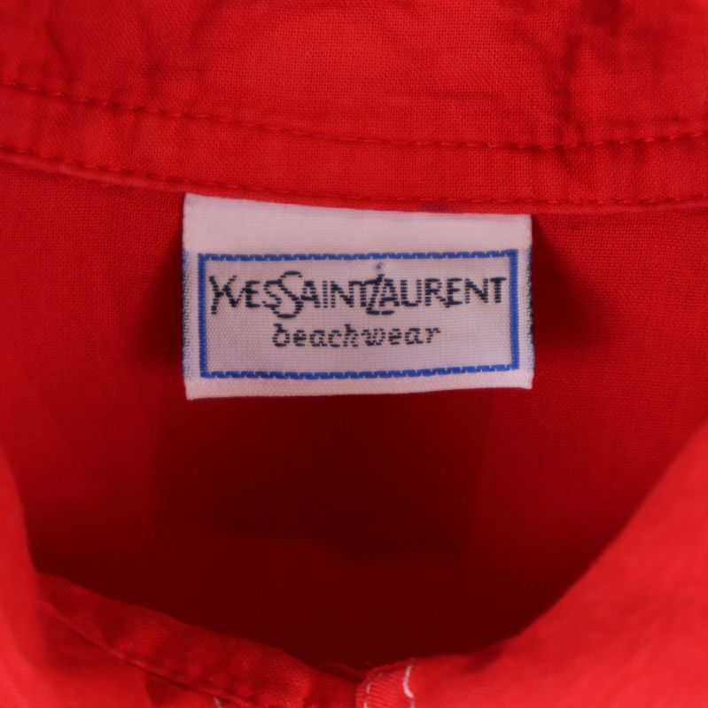Närbild på vit etikett i nacken med texten Yves Saint Laurent beachwear