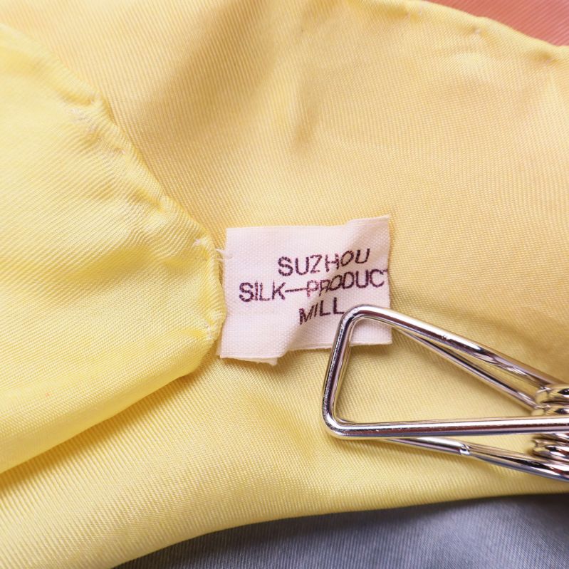 Etikett med texten SUZHOU SILK PRODUCT MILL fäst vid scarfen