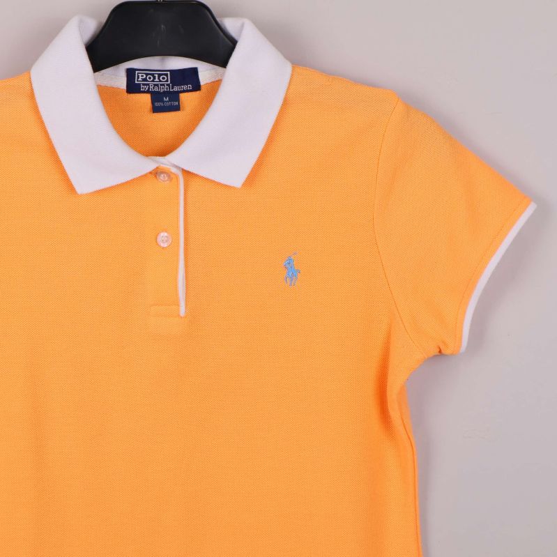 Närbild på vänster bröst och krage med blå logga