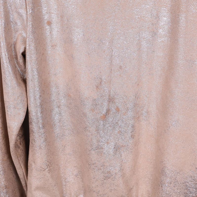 Närbild på skimrande material och sömmar bak på jackan