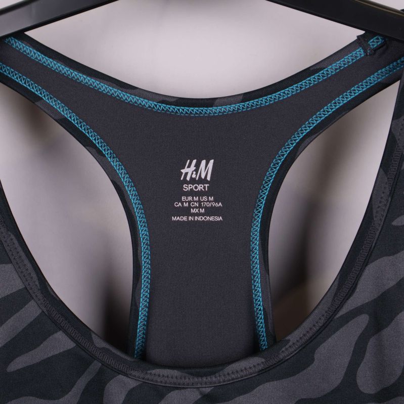 Närbild på H&M sportlogotyp och blå sömmar i nacken