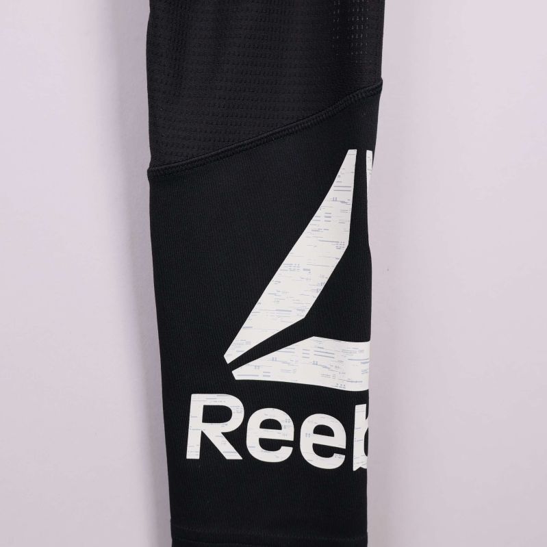 Närbild där bokstäverna i Reebok-loggan syns tydligt