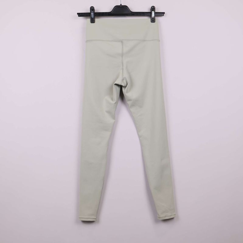 Ljusbeiga leggings bakifrån på galge mot ljus bakgrund