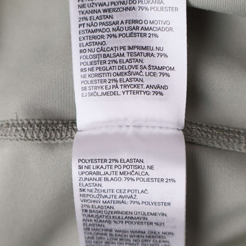 Textetikett med polyester 79 procent och elastan 21 procent
