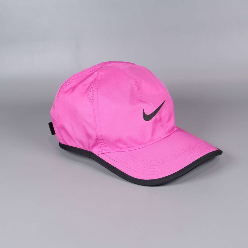 Rosa Nike-keps med svart kant sedd snett framifrån