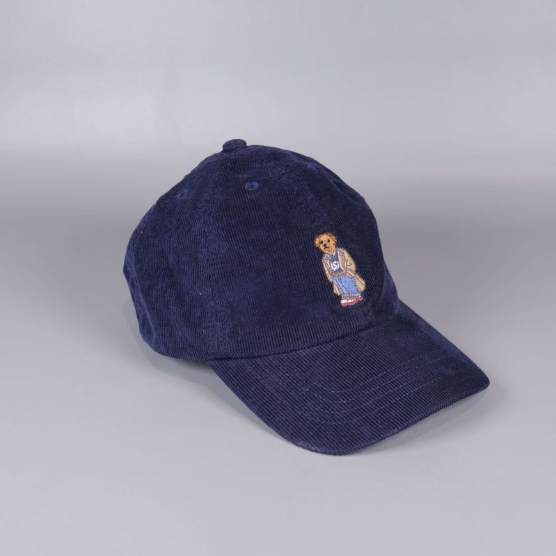 Mörkblå keps i manchester med broderad björn framtill
