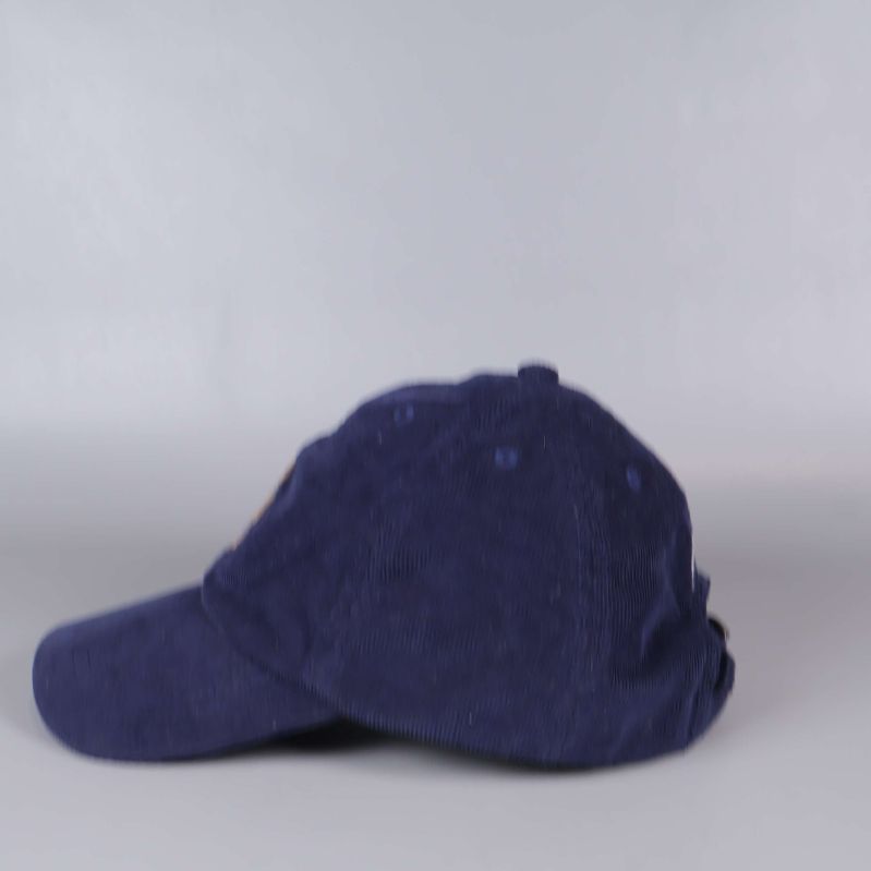 Sidan av kepsen i mörkblå manchester utan synliga detaljer