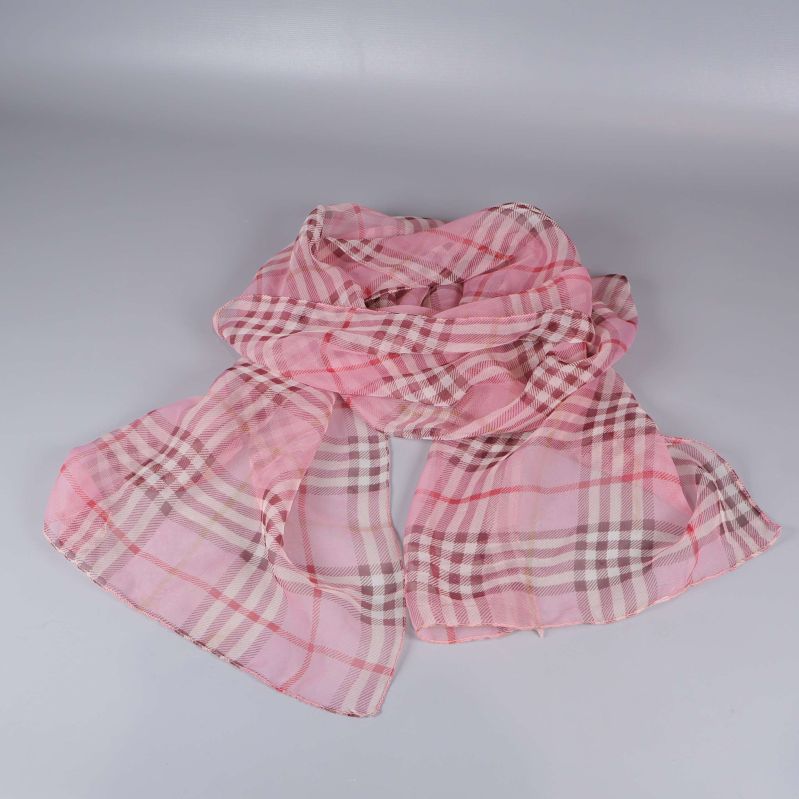 Rosa rutig sjal liggande utbredd på ljus bakgrund