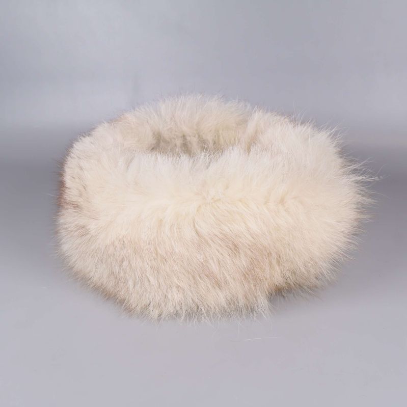 Fluffig cremevit pälskrage liggande på grå bakgrund