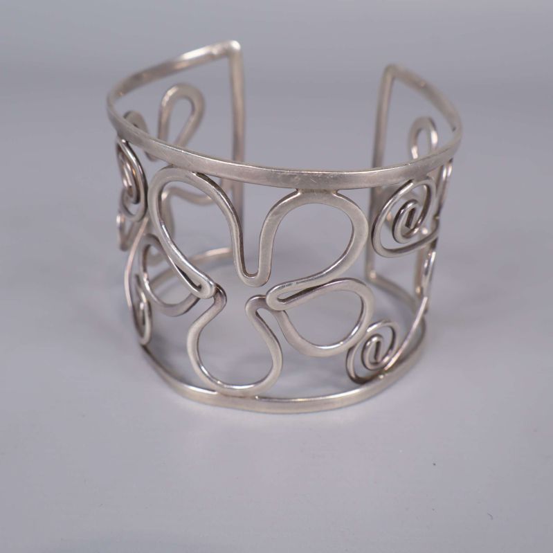 Framifrån vy av armring med blom- och snirkelmönster