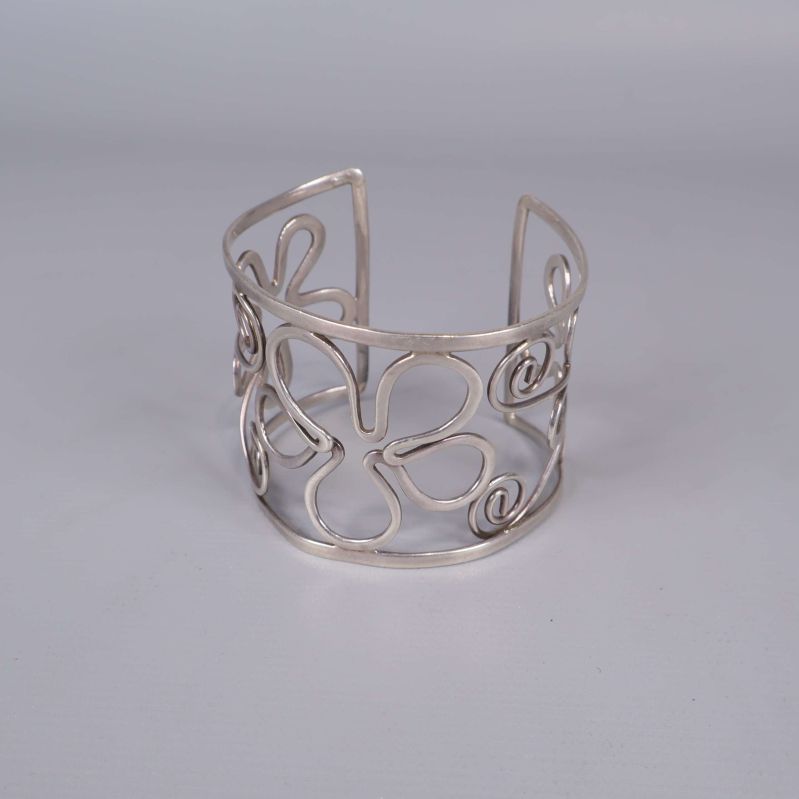 Öppen armring med blommönster mot ljus bakgrund