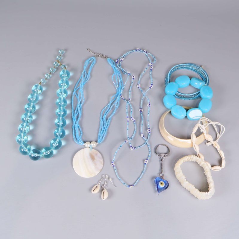 Set med blå och vita smycken och accessoarer i olika former