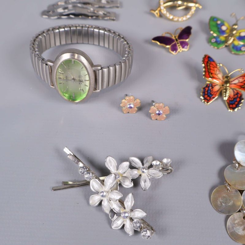 Grönt armbandsur och blommiga hårspännen i silverfärg