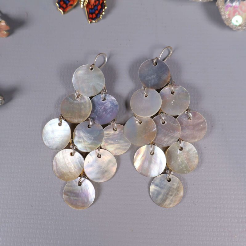 Stora örhängen av pärlemorfärgade runda skivor