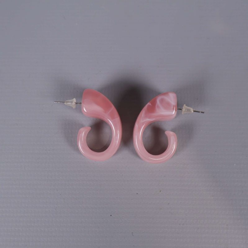 Rosa örhängen parade på ljus bakgrund ovanifrån