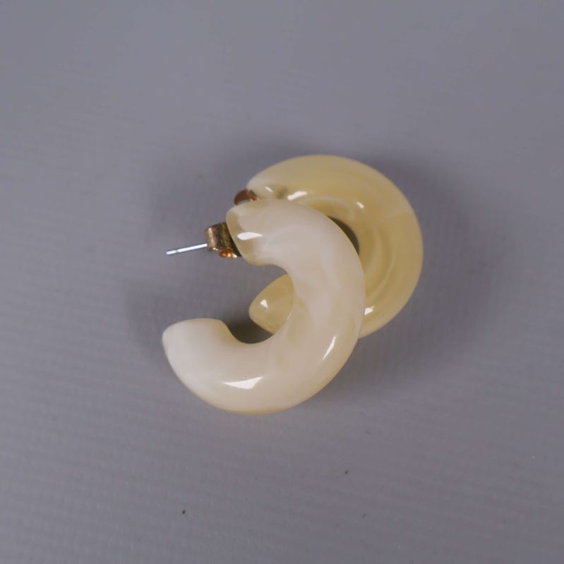 Närbild på två tjocka ringformade örhängen