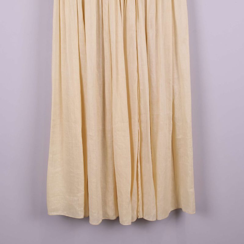 Nedre del av ljus gul plisserad kjol
