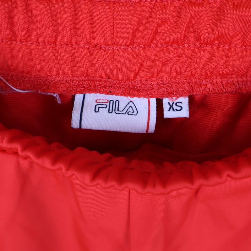 Närbild på FILA-logga och storlekslapp XS i midjan