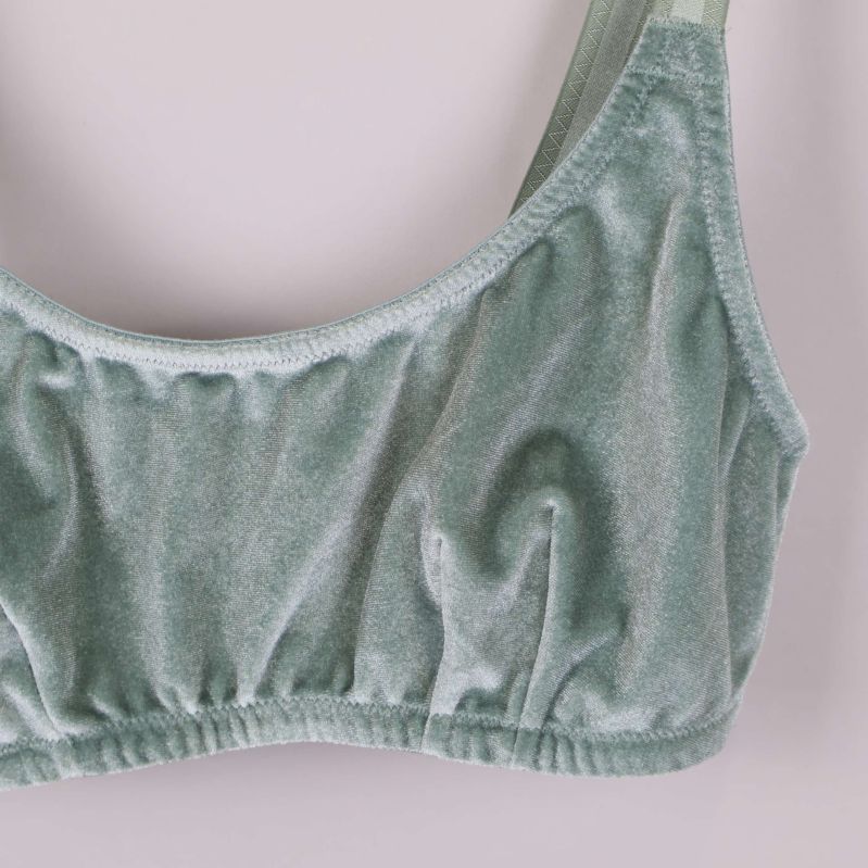 Framsida i närbild på ljusgrön velour-bh med elastisk kant