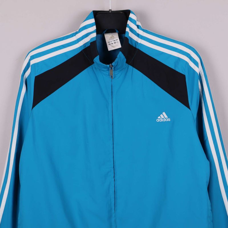 Närbild av Adidas sportjacka med vit logga på bröstet