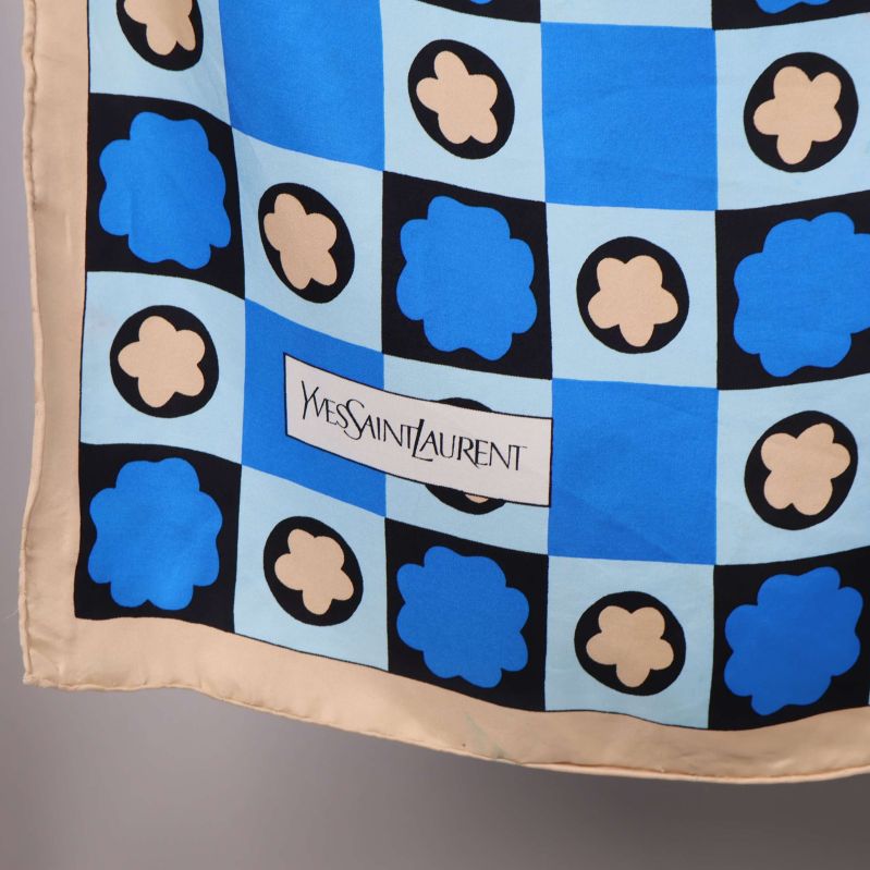 Närbild på scarf med Yves Saint Laurent-logga