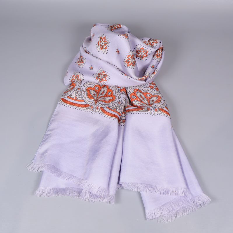 Sjal med fransad kant och blommönster ligger hopvikt