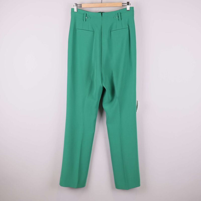 Gröna kostymbyxor sedd bakifrån visar fickor