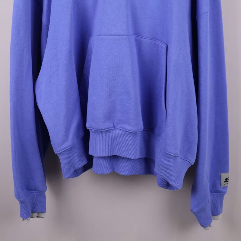 Nederkant och ärmslut på blå hoodie med ribbade muddar