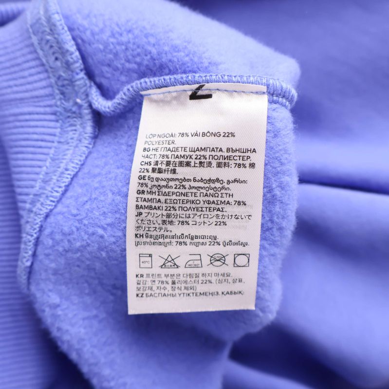 Närbild på skötsel- och materialtvättlapp inuti blå hoodie