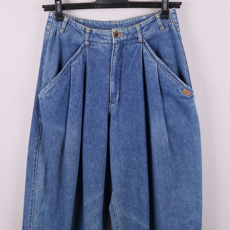 Närbild på jeansens framtill med detaljerade fickor och veck