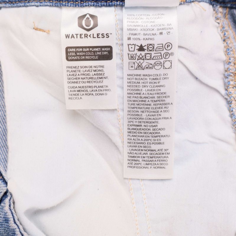 Materialetikett visar 100 procent bomull på jeanskjol