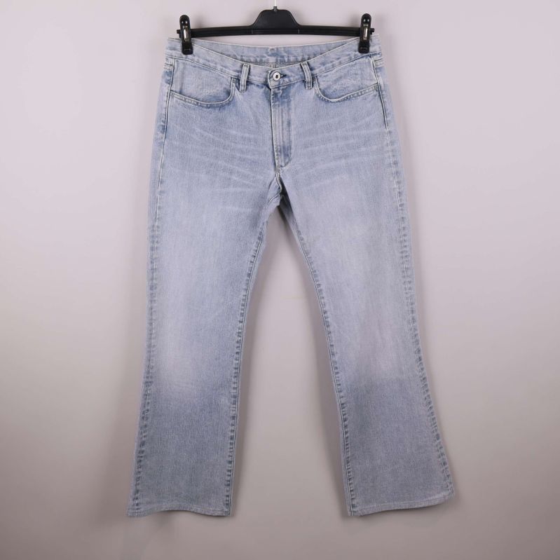 Framsidan av ljusblå raka jeans på galge