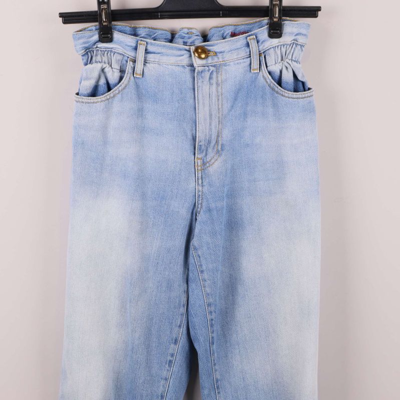 Närbild på övre del av jeansen med rynkad midja och fickor