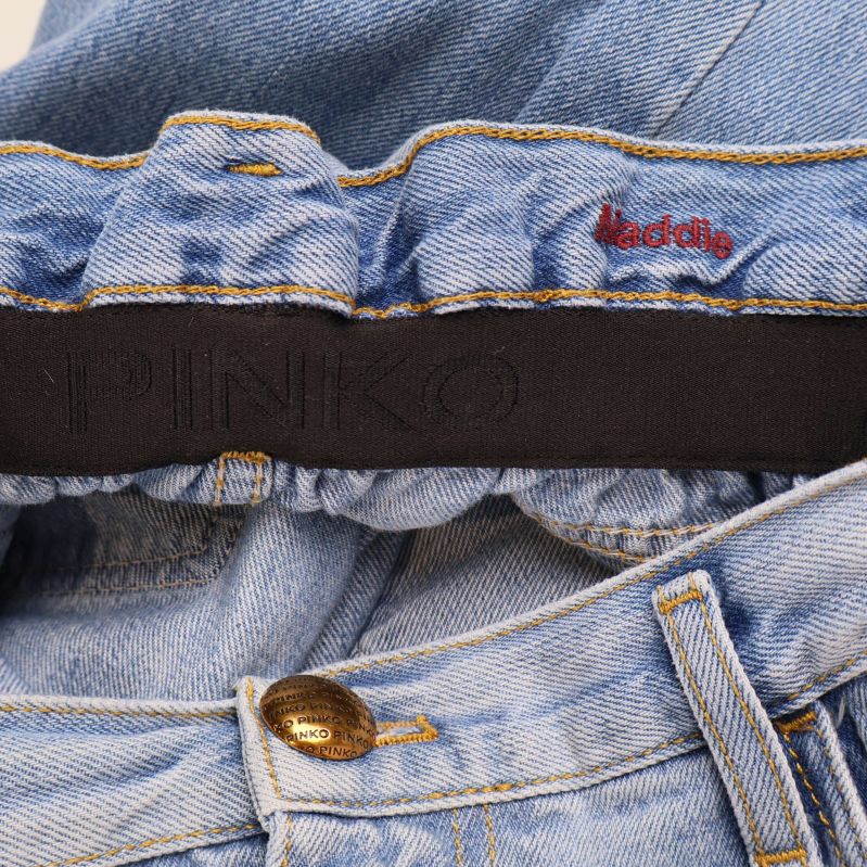 Detaljbild på elastisk linning med Pinko-logga och knapp