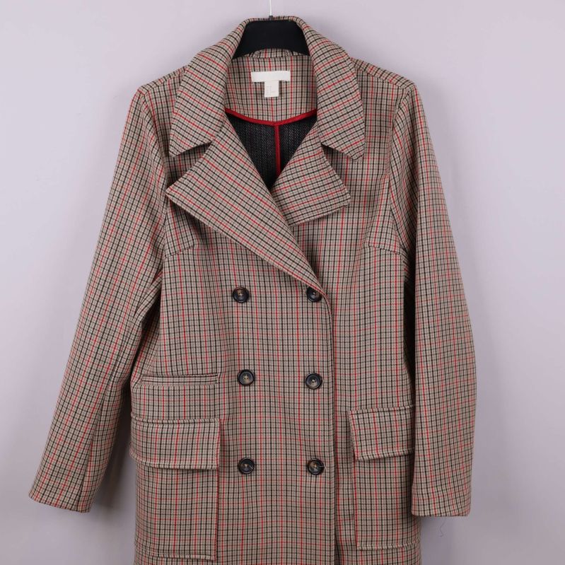 Närbild på kappans rutiga framstycke och knappar