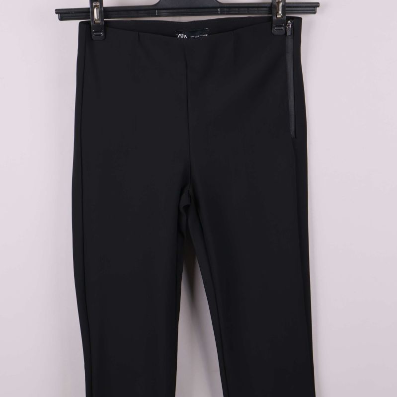 Närbild av övre del på smal svart byxa framifrån