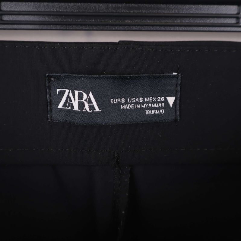 Närbild på ZARA-märke och storlekslapp i linningen