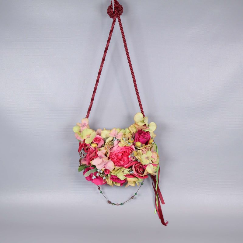 Blommig axelväska upphängd med röd reprem