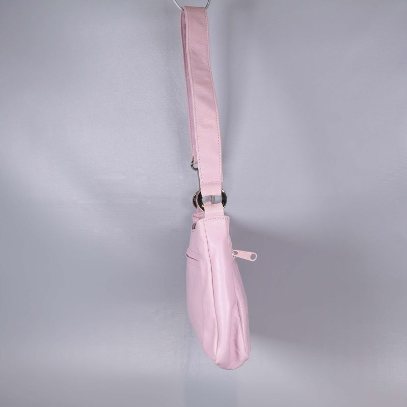 Sidan på den ljusrosa axelremsväskan i profil