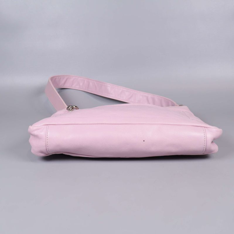 Botten av ljusrosa axelremsväska mot grå bakgrund